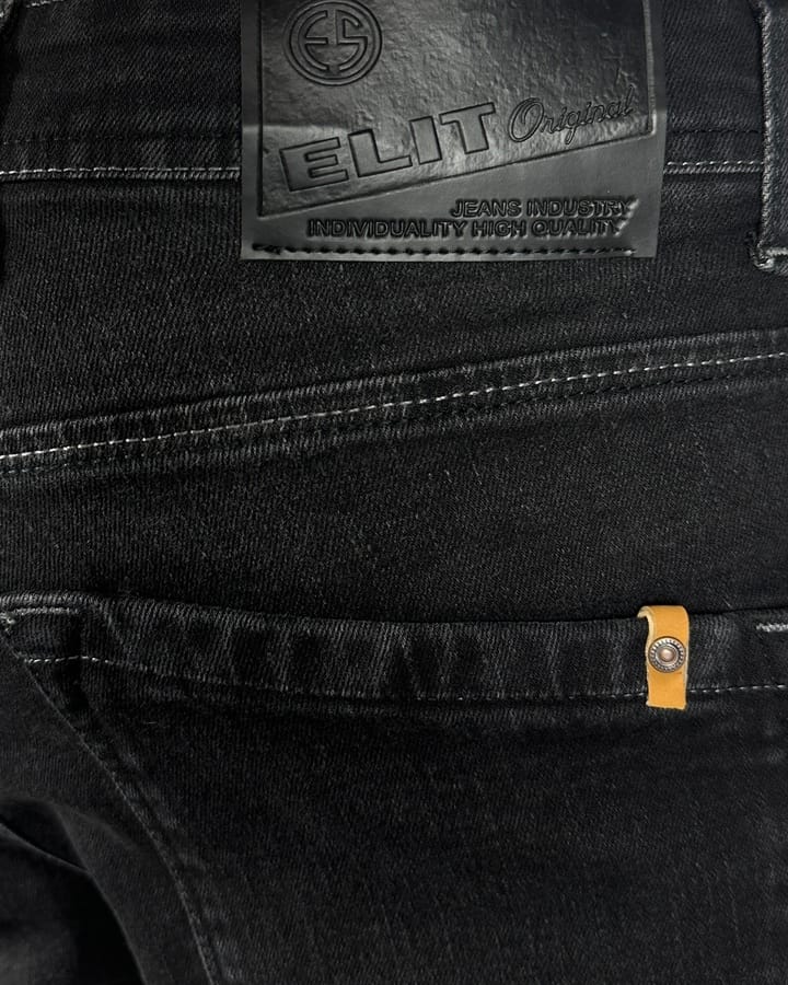 Kožna etiketa sa ELIT logom na zadnjem džepu crnih farmerki.